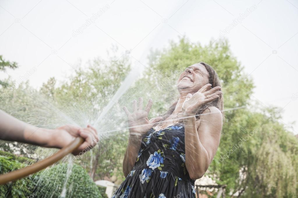 Couple playing with a garden hose