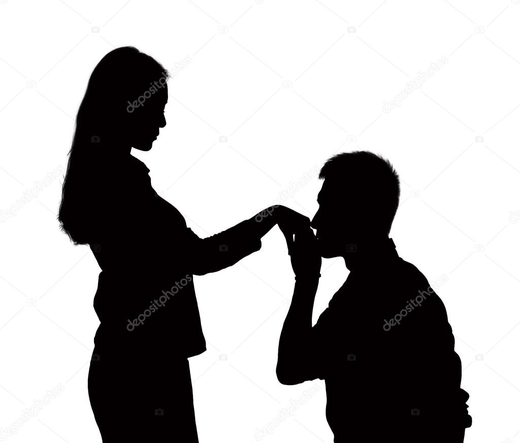 Silhouette of man on one knee, kissing woman's hand