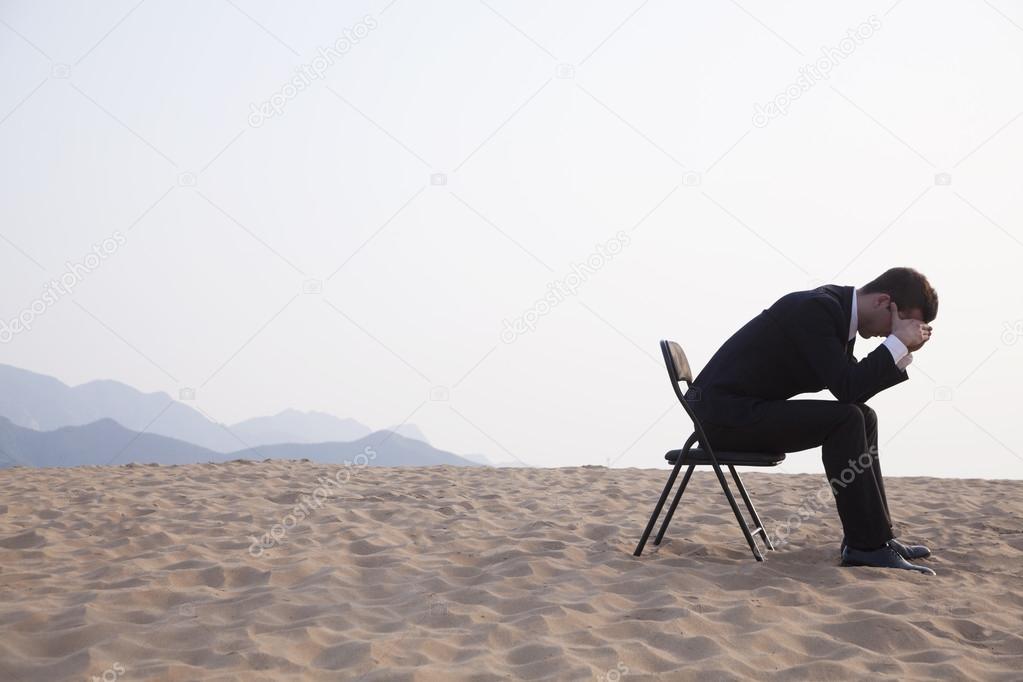 Businessman sitting with his head in his hands