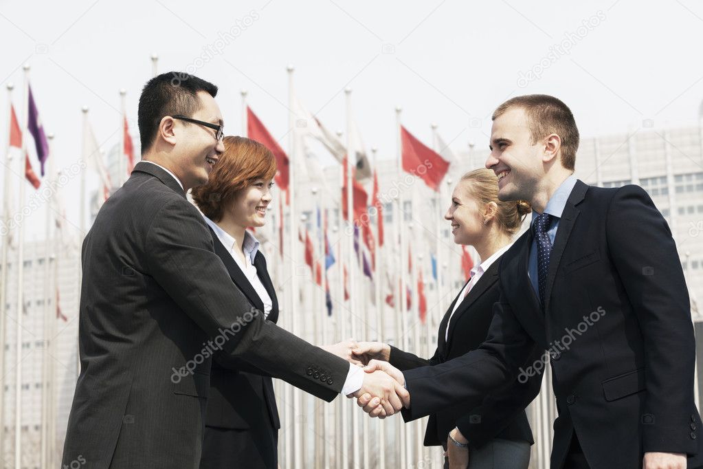 Business people meeting and shaking hands outdoors