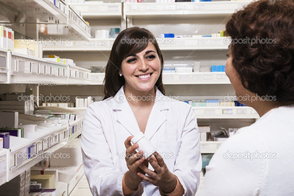 Pharmacist showing prescription medication to a customer