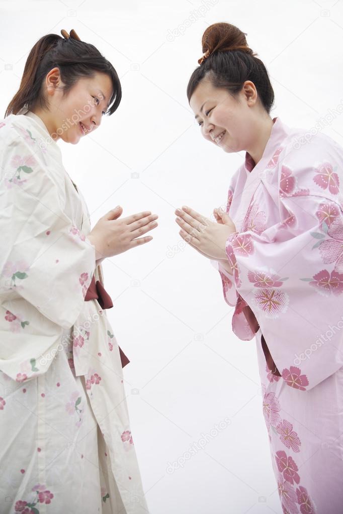 Woman in Japanese kimonos bowing to each other