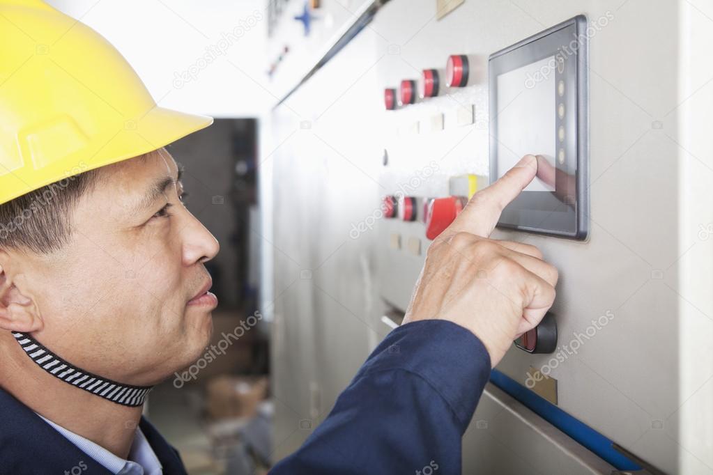 Worker checking controls in a gas plant