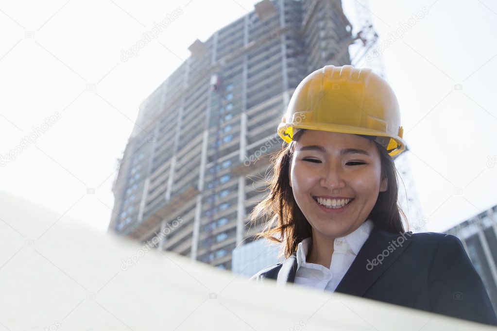 Architect looking down at blueprint outdoors