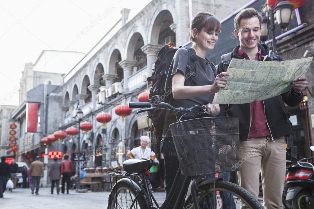 Man and woman with bicycle and map
