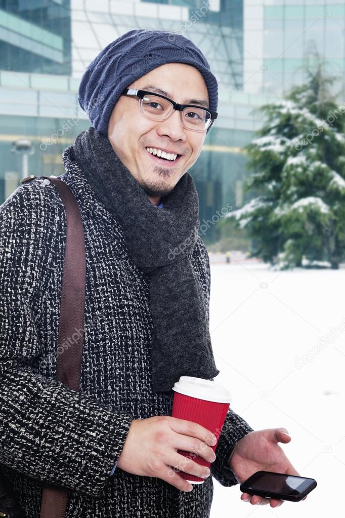 Man in winter clothes holding coffee cup