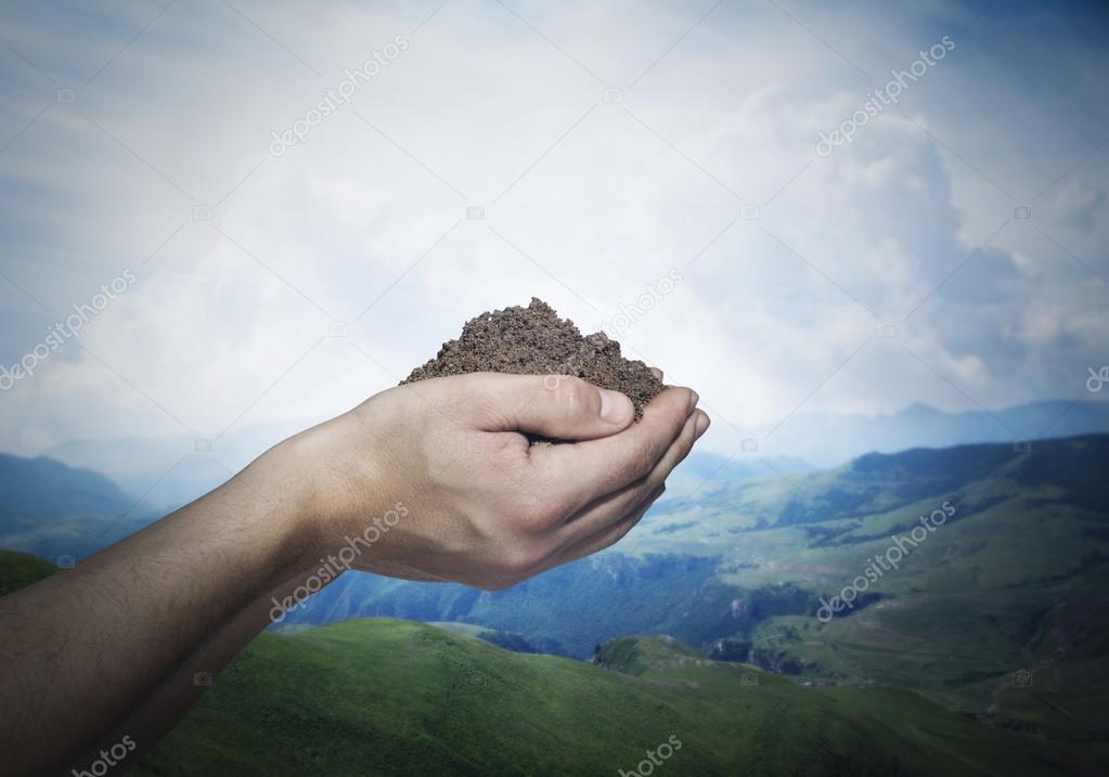 Hands holding a pile of soil
