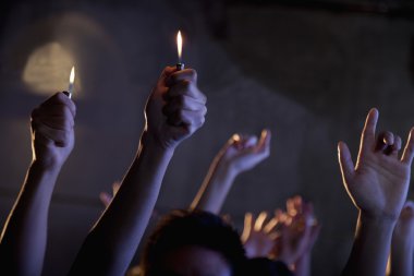 People holding cigarette lighters at a concert clipart