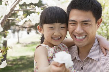 pai e filha, apreciando as flores de cerejeira