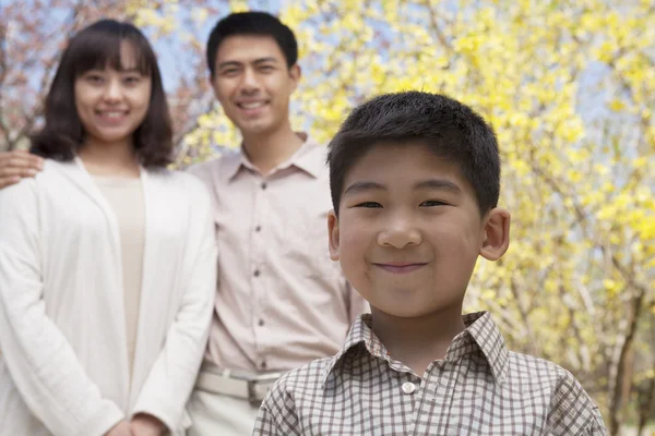 Usmívající se rodina v parku v jarní — Stock fotografie