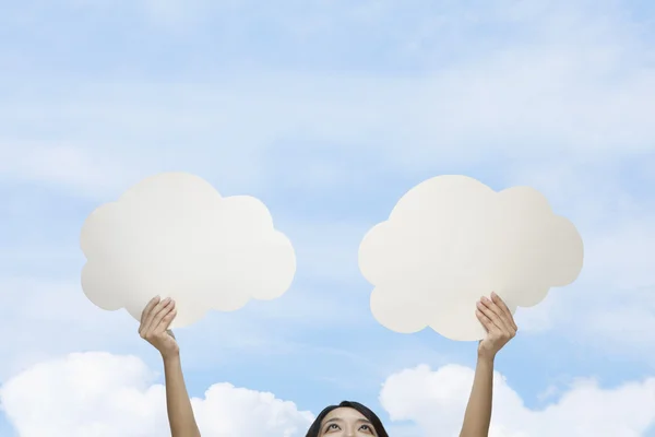 Woman holding two cut out paper clouds — Stock Photo, Image