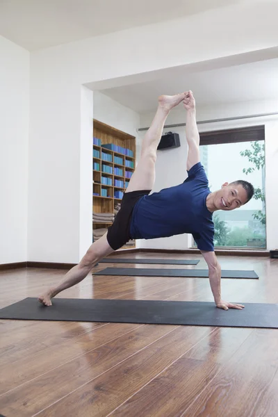 Man doen yoga in een yogastudio — Stockfoto