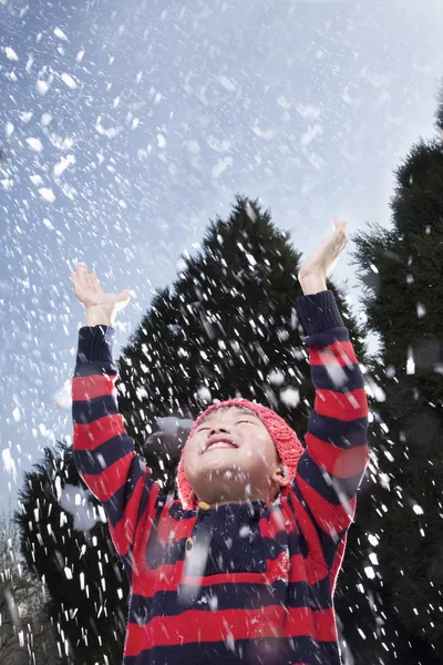 Junge mit erhobenen Armen fühlt den Schnee — Stockfoto