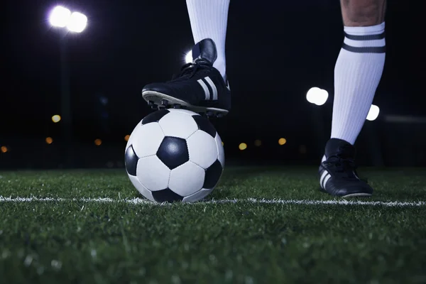 Ноги на вершині футбольного м'яча на лінії — стокове фото