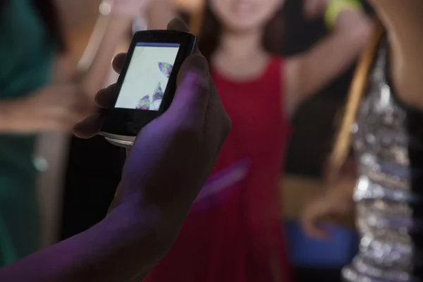 Man maakt gebruik van een mobiele telefoon in nachtclub — Stockfoto
