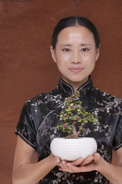 Vrouw met een kleine plant — Stockfoto