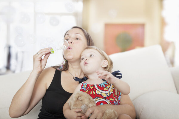 Mother and daughter blowing bubbles