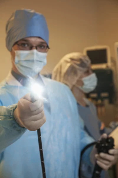 Cirurgião segurando um instrumento médico — Fotografia de Stock