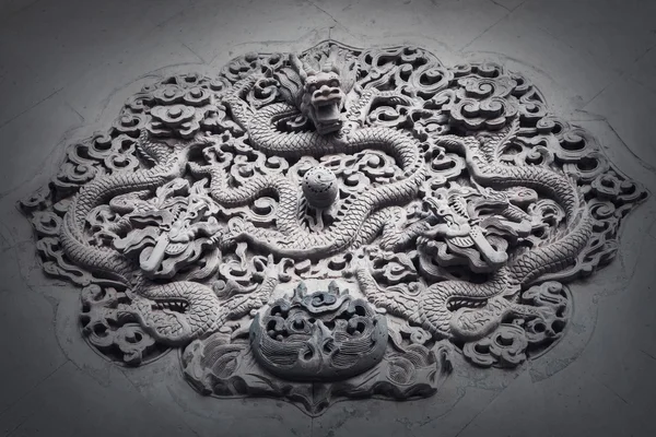 Ornate low relief sculpture of dragon on wall — Stock Photo, Image