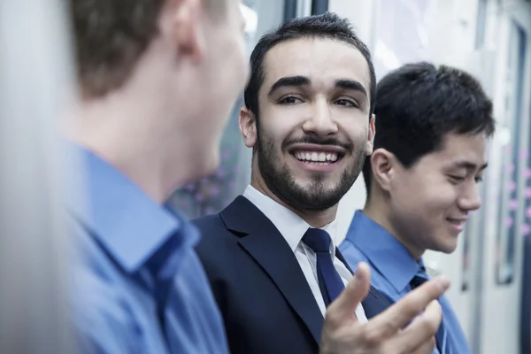 Businessmen talking on the subway — Stock Photo, Image