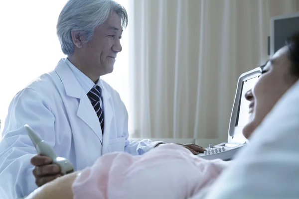 Doctor doing an ultrasound on a pregnant woman — Stock Photo, Image