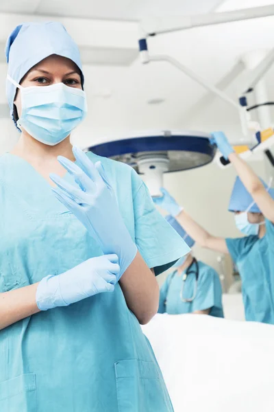 Surgeon putting on gloves in the operating room Royalty Free Stock Images