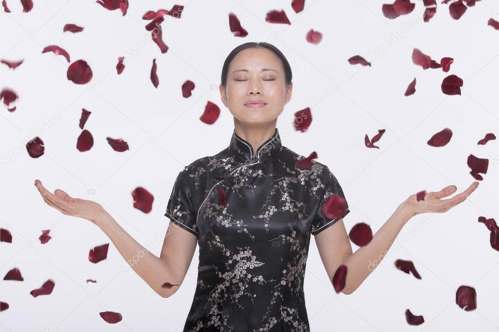 Woman with rose petals coming down around her
