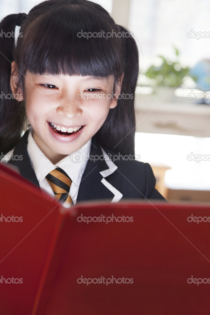 Schoolgirl reading a book with her face lit up