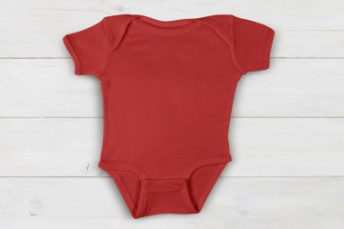 Neşeli kırmızı tulum, çağdaş beyaz ahşap arka planda tembelce dinleniyor..