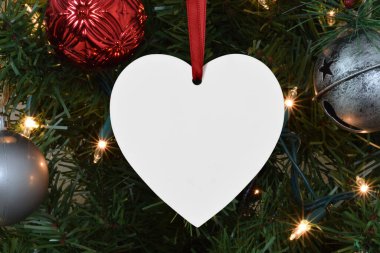 Boş kalp süsü ışıl ışıl bir Noel ağacının dalından sarkıyor..