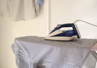 het shirt en de ijzer op de strijkplank