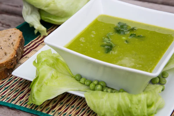 Green peas cream soup with salad leaves — Stock Photo, Image