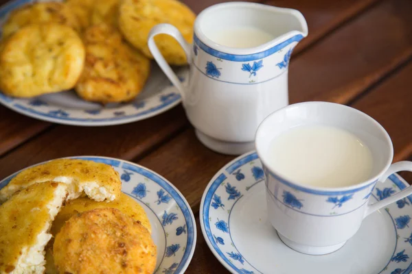 Homemade cheese pancake and a cup of warm milk — Stock Photo, Image