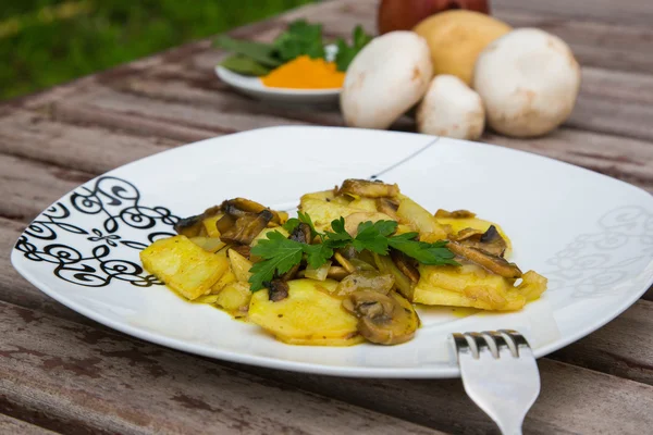 Pommes de terre cuites au four avec des champignons et du persil sur la plaque blanche . — Photo