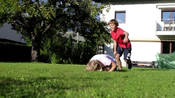 Niños Pequeños Saltando Uno Sobre Otro Mientras Juegan Juntos Patio — Vídeo de stock