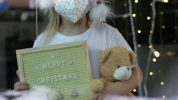 Girl Medical Mask Holding Holiday Wooden Frame Teddy Bear Home — Stockvideo