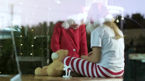 Twee Kinderen Met Kerstmutsen Thuis Met Cadeaudoosjes — Stockvideo