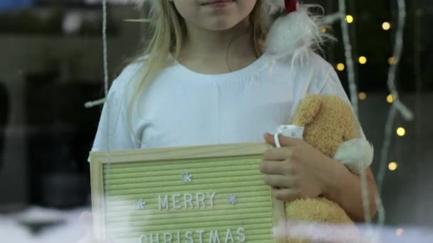 Noel Elinde Tahta Çerçeveyle Evde Oyuncak Ayı Tutan Bir Kız — Stok video
