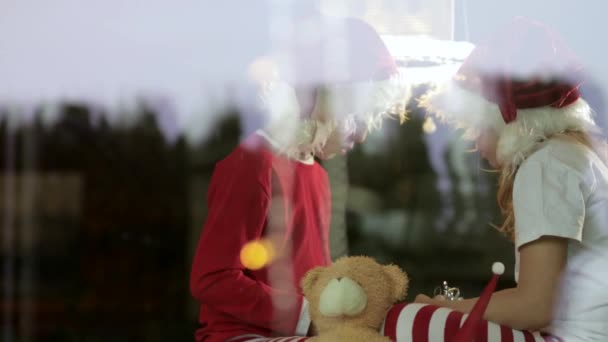 Duas Crianças Usando Chapéus Natal Sentadas Com Caixas Presente Casa — Vídeo de Stock