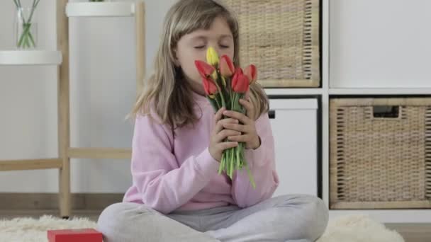 Kaukázusi lány egy ajándék és egy csomó tulipán — Stock videók