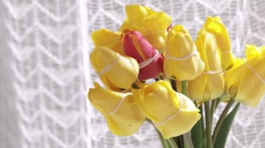 Bunch of yellow tulips in the glass vase.