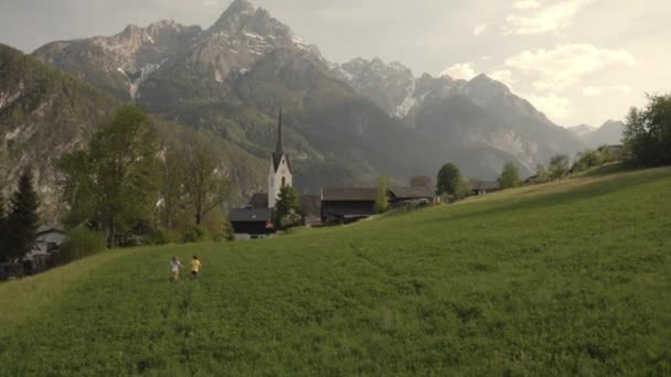 Sister and the brother are running together in the field. — Vídeo de Stock