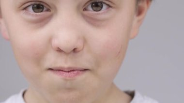 Caucasian boy of 9 years expresses unsatisfaction with a smell in the room.