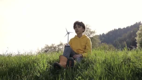 Boy Dressed Yellow Hoodie Keeps Model Wind Turbine Field High — Vídeo de stock