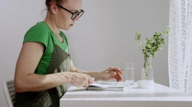 Kafkas kadın sabah erken saatlerde ajandasına yazı yazacak. Yavaş çekim