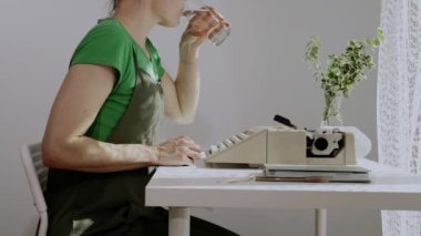 Kadın oyun yazarı, sabahın erken saatlerinde mesaj yazmadan önce su içer. Yavaş çekim