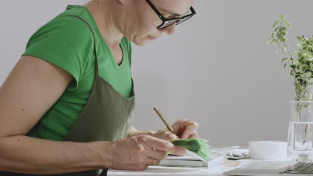 Biała Kobieta Między Rokiem Życia Robi Notatki Trzymając Pieniądze Rękach — Wideo stockowe