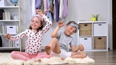 Pijama giymiş kız ve erkek kardeş birlikte eğleniyorlar. Ağır çekim. Yüksek kalite 4k görüntü