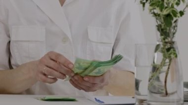 Medikal kız kardeşlerin giydiği beyaz kadın para sayıyor. - Yakın çekim. Yüksek kalite 4k görüntü