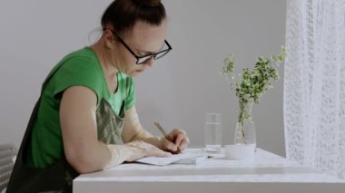 Kafkas kadın sabah erken saatlerde ajandasına yazı yazacak. Yavaş çekim